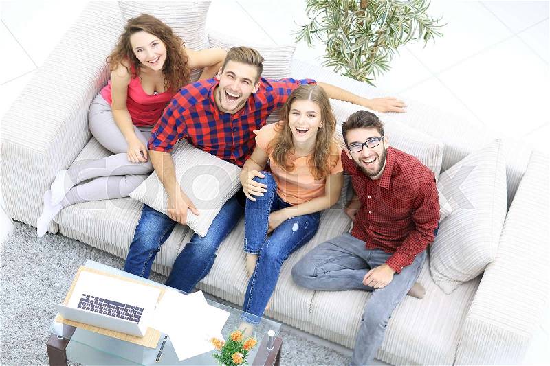 View from the top.a group of laughing friends sitting on the sofa, stock photo