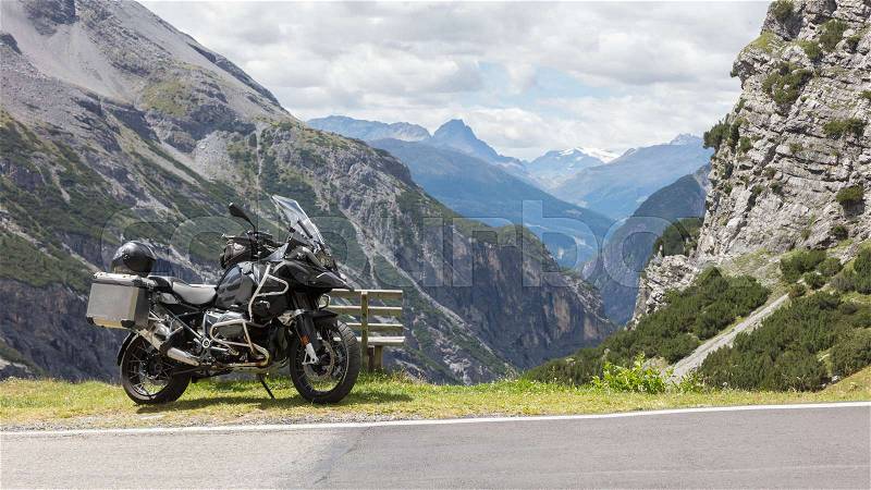 Unrecognisable motorcycle and driver in the Alps - Enjoying the scenery, stock photo