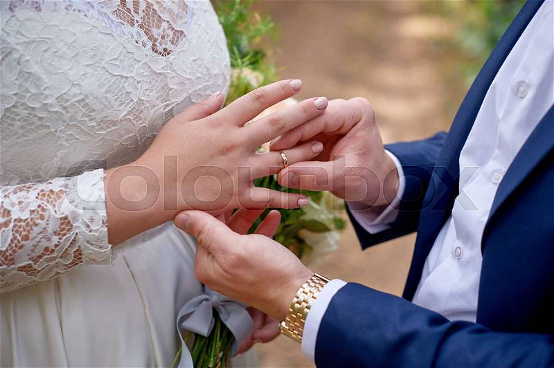 Groom dresses the bride ring on her finger, stock photo