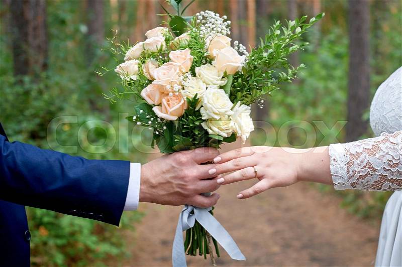 Bridegroom gives the bride a wedding bouquet for a walk in the park, stock photo