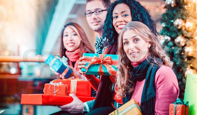 Diversity Friends with Christmas presents and bags shopping in mall with light decoration, stock photo