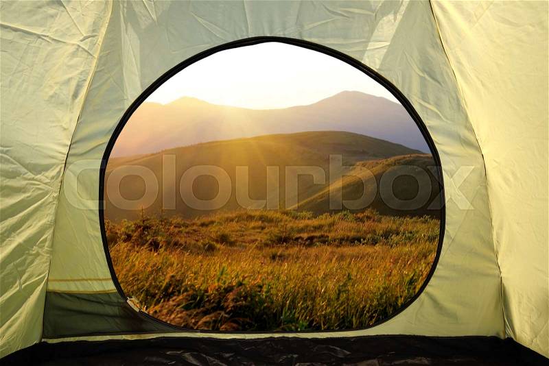 View from inside a tent on mountains landscape. Travel lifestyle concept adventure vacations outdoor, stock photo
