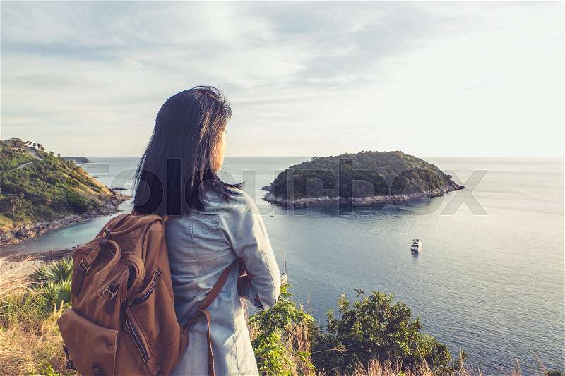 Young traveler woman standing and looking at view enjoying a beautiful of nature at top of mountain and sea view,Freedom wanderlust backpacker concept,vintage filter, stock photo