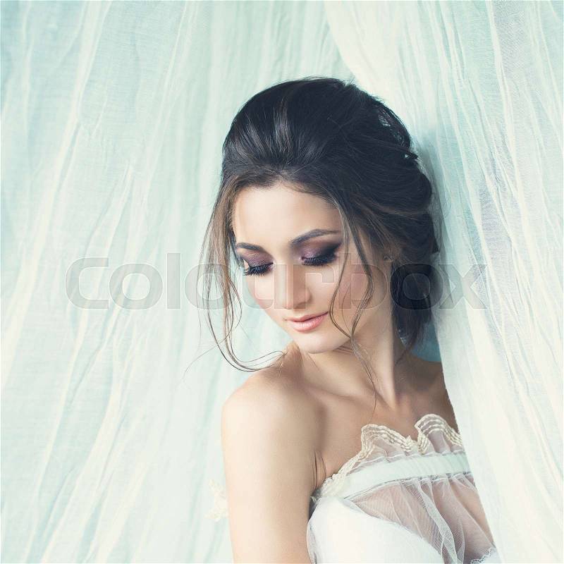Beautiful Young Woman Fiancee with Bridal Hairstyle and Event Makeup on White Cloth Background, stock photo