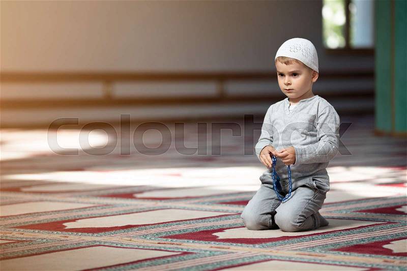 Ramadan Kareem,The Muslim boy prays in the mosque, the little boy prays to God,Peace and love in the holy month of Ramadan,lifestyle concept, stock photo