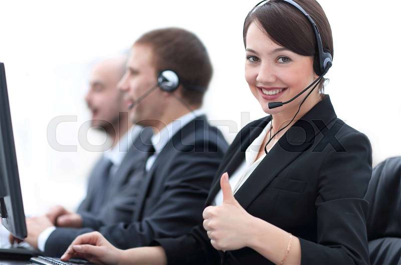 Manager of the call centre shows thumb up sitting at your Desk in the workplace, stock photo