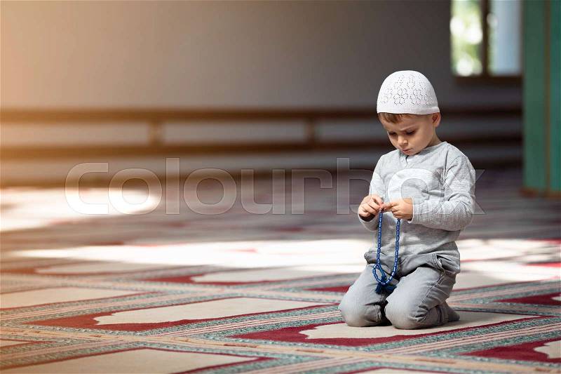 Ramadan Kareem,The Muslim boy prays in the mosque, the little boy prays to God,Peace and love in the holy month of Ramadan,lifestyle concept, stock photo