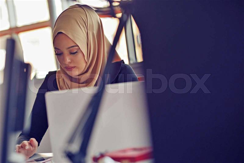 Muslim asian woman working in office with laptop, stock photo
