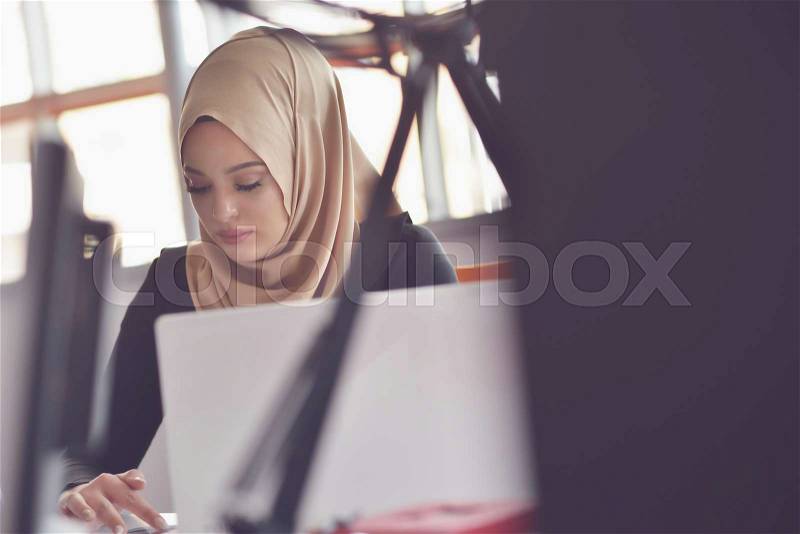 Muslim asian woman working in office with laptop, stock photo