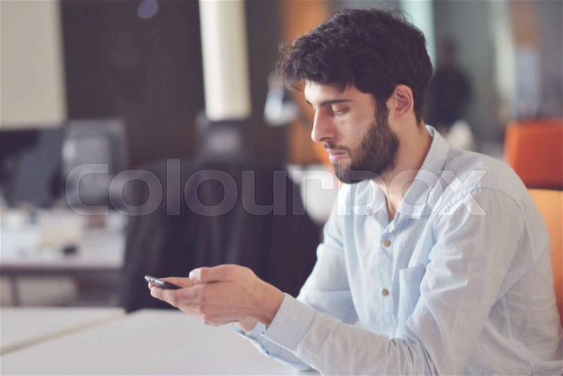 Young business man working on desktop computer at his desk in modern bright startup office interior, stock photo