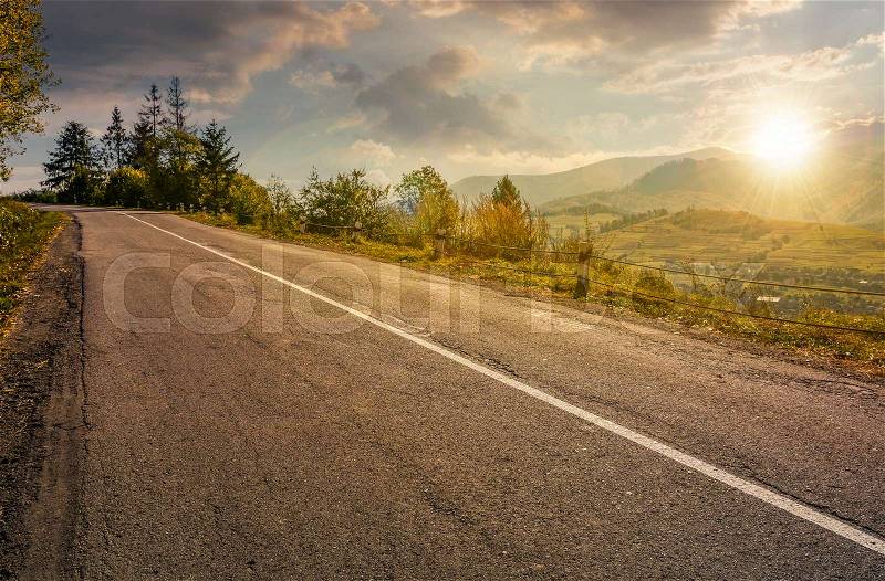 Countryside road through mountains at sunset. lovely autumnal scenery, stock photo