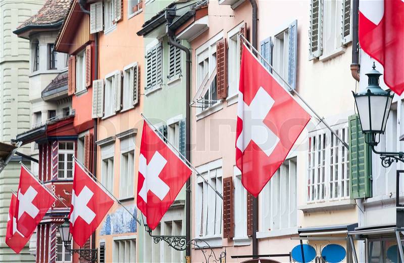 Ancient street Augustinergasse in Zurich decorated with swiss flags, stock photo