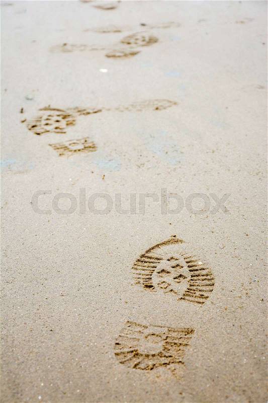 Several Footprints of shoes in the sand from the front, stock photo