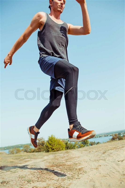 Running sport. Man runner sprinting outdoor in scenic nature. Fit muscular male athlete training trail running for marathon run. Sporty fit athletic man working out in compression clothing in sprint, stock photo