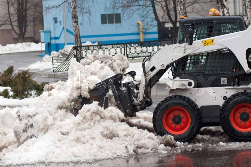 Snow cleaning machine on the streets of the city in winter, stock photo
