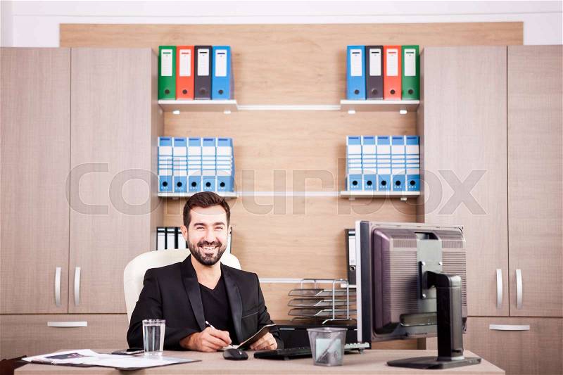 Happy Businessman working in his office. Businessperson in professional environment, stock photo