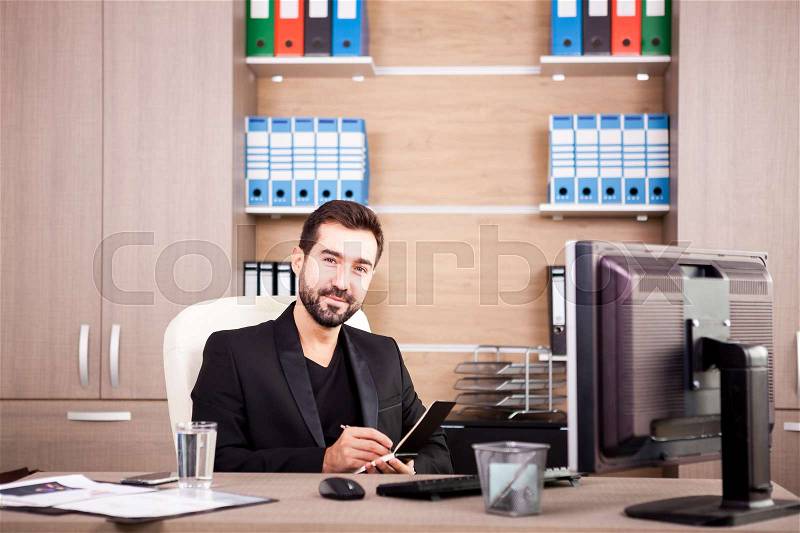 Happy Businessman working in his office. Businessperson in professional environment, stock photo