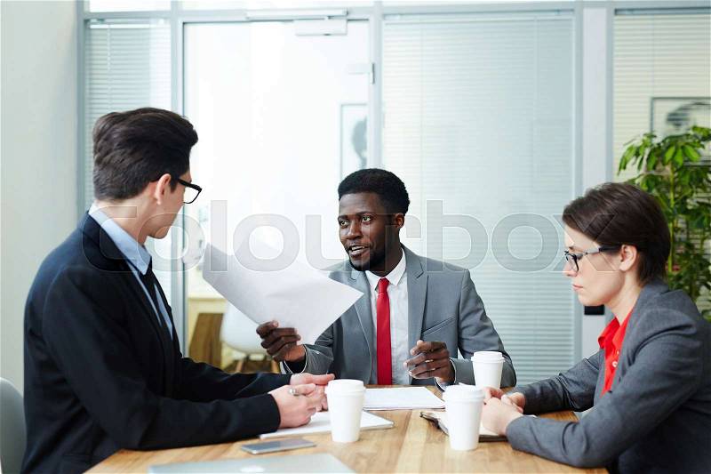 Confident employers interviewing one of candidates for new vacancy, stock photo