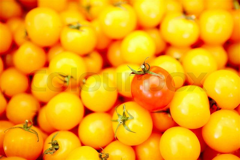 Red and yellow tomatoes in heap sold in supermarket, stock photo