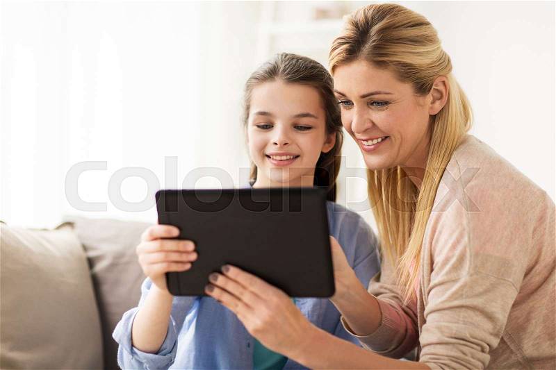 People, family and technology concept - happy girl and mother with tablet pc computer at home, stock photo