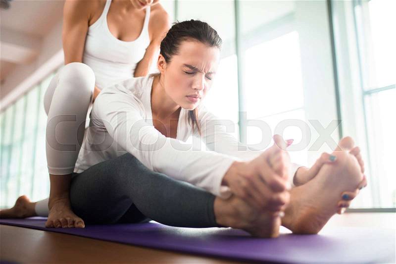 Sweating girl making effort while doing physical exercise with her trainer in gym, stock photo