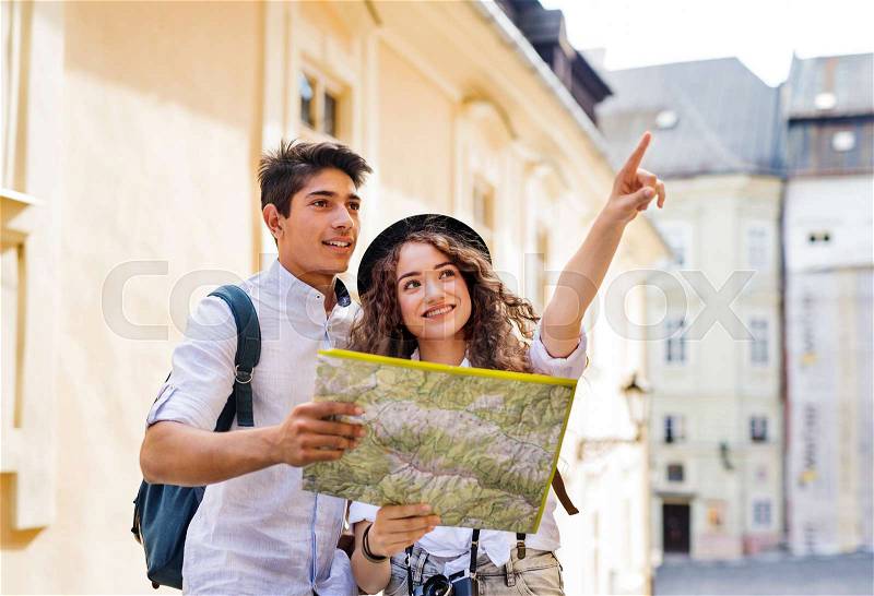 Two beautiful young tourists with map and camera in the old town, stock photo