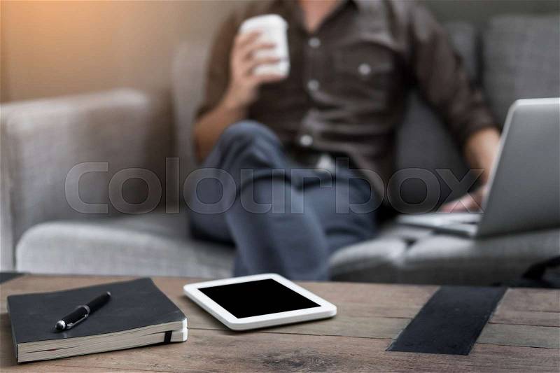 Business working desktop with Businessman works on the sofa at home searching for new idea creative and drinking hot coffee background, stock photo