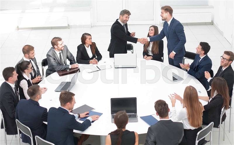 Business partners shake hands at the talks near the round table .the concept of partnership, stock photo