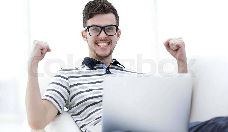 Happy man with laptop sitting on the couch. photo with copy space, stock photo