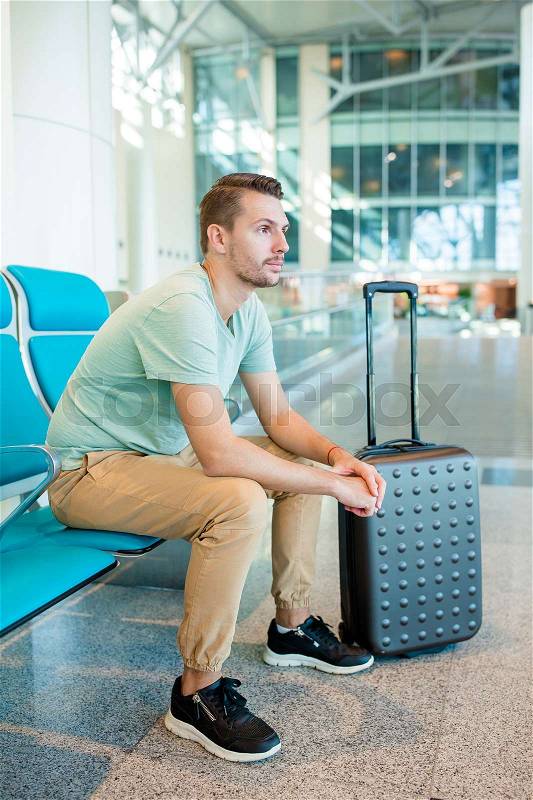 Airline passenger in an airport lounge waiting for flight aircraft, stock photo