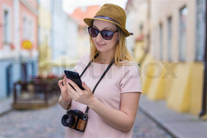 Portrait of young woman tourist with camera and smart phone, stock photo