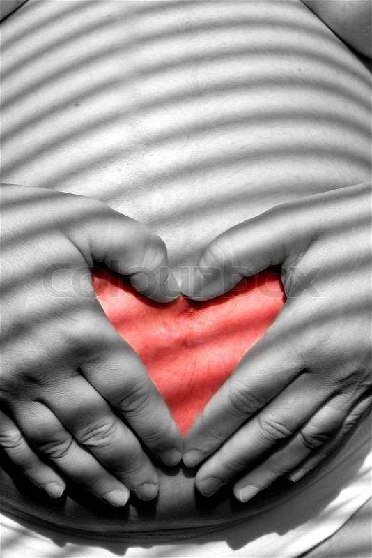 Heart from hands on belly pregnant women - 36 week gravidity, stock photo