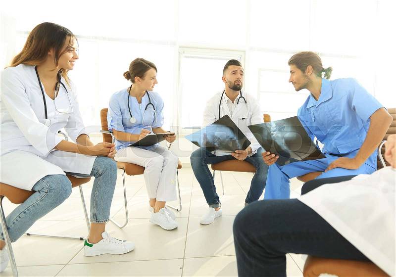 Group of surgeons and medical professional staff discussing on patient radiography in the office, stock photo