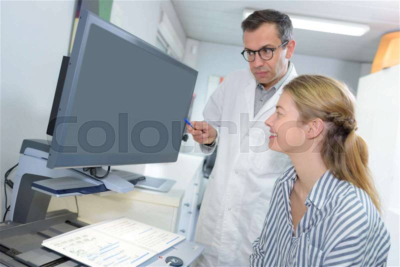 Female mature students discussing with teacher, stock photo