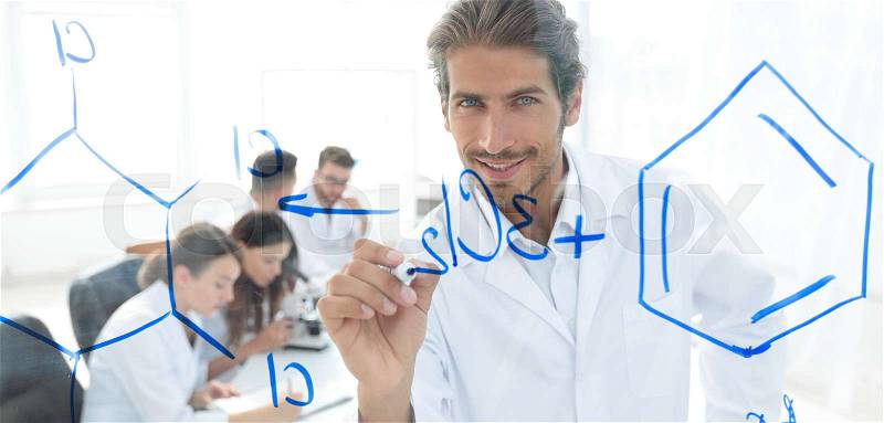 View through the transparent Board. smiling scientist records data on a glass Board, stock photo