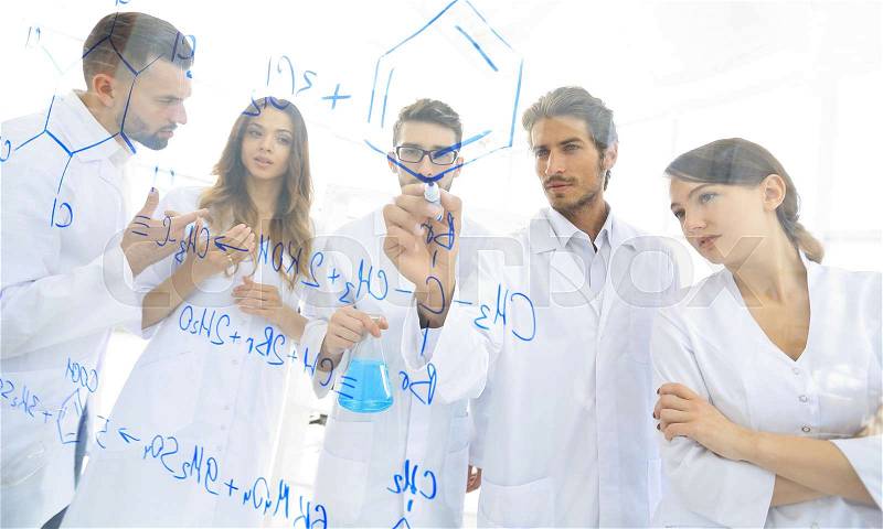 General-view seen trough a transparent board in a chemistry lab of people analyzing information, stock photo