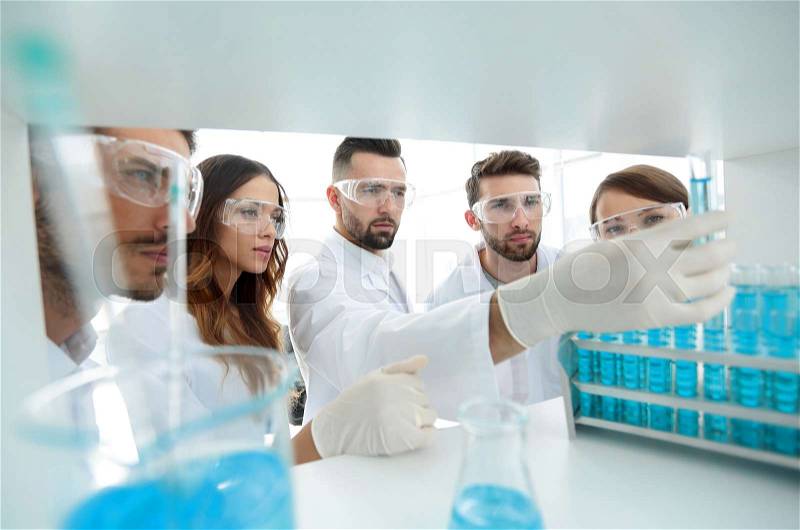 Group of microbiologists studying the liquid in the glass tube. the concept of the research, stock photo