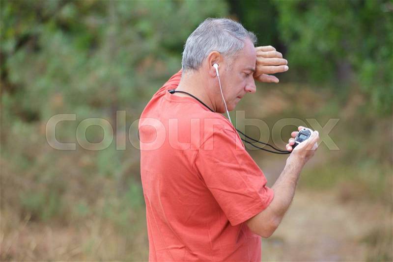 Middle-age male jogger taking a break from running workout, stock photo