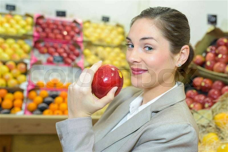 Pretty woman buying fresh fruits and vegetables at food-store, stock photo