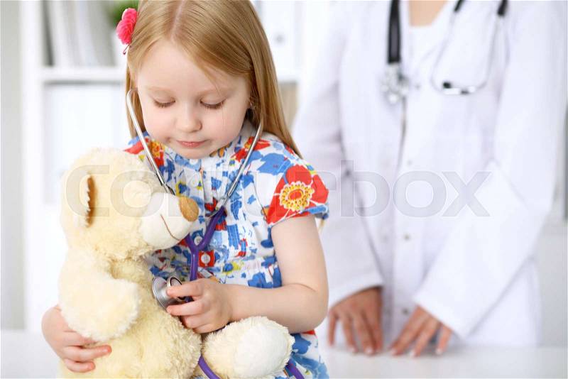 Little girl examining her Teddy bear by stethoscope. Health care, child-patient trust concept, stock photo