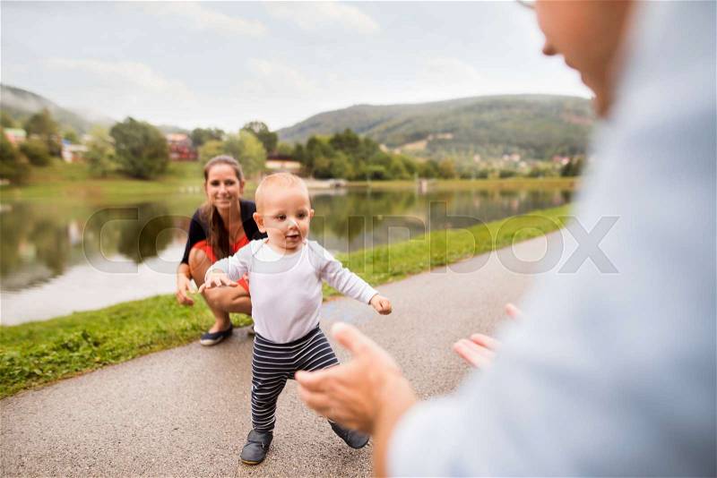 Cute little boy making first steps in nature. Young family spendind time in nature. Summer time, stock photo