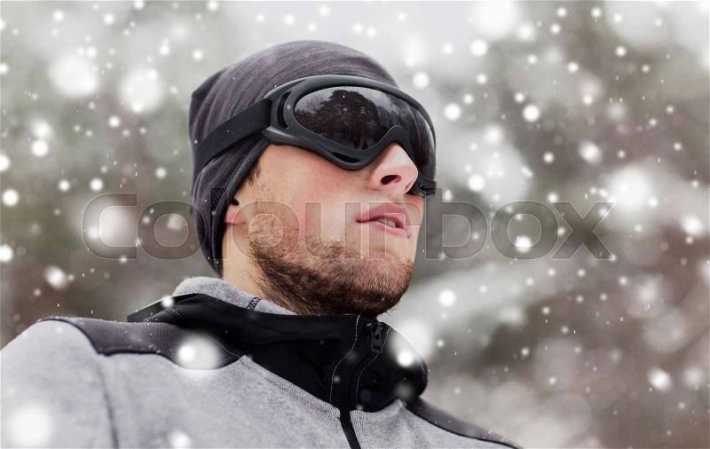 Fitness, winter sport, people and healthy lifestyle concept - young man in ski goggles outdoors, stock photo