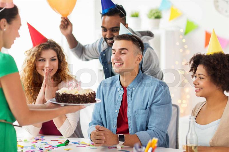 Corporate party and people concept - happy team with cake and non-alcoholic drinks celebrating colleague 21st birthday at office party, stock photo