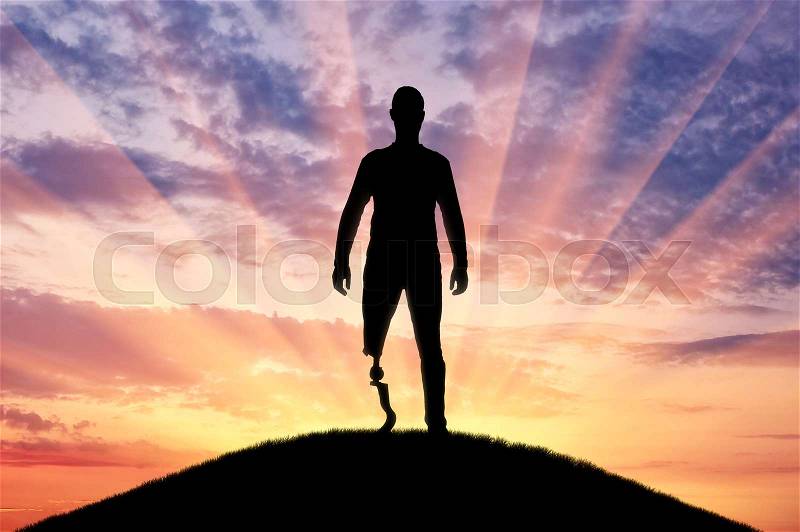 A man with a prosthetic leg standing on the sunset. The concept of prosthetic legs and rehabilitation, stock photo