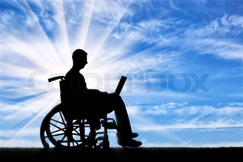 A disabled person in a wheelchair working with a laptop in his hands. The concept of the opportunity to work for people with disabilities, stock photo
