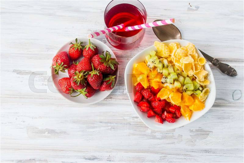 Cornflakes and Rainbow fruit salad , strawberry in plate , glass juice for - a healthy breakfast. The concept of proper nutrition. Top view. Copy space, stock photo