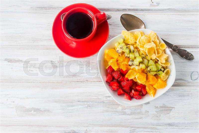 Cornflakes and Rainbow fruit salad ,cup of coffee - a healthy breakfast. The concept of proper nutrition. Top view. Copy space, stock photo