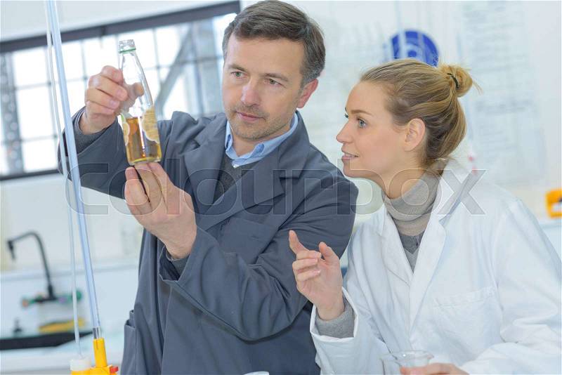Scientists working with liquids in the lab, stock photo