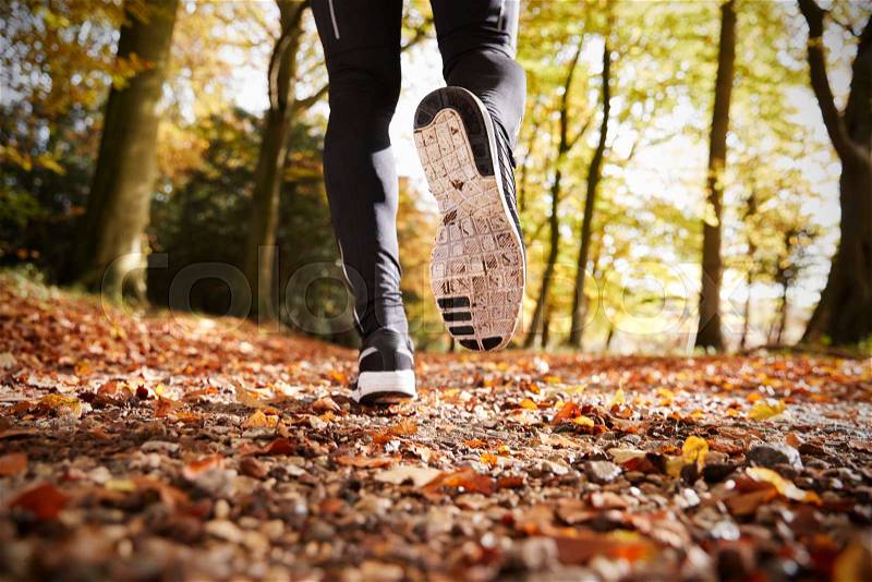 Close Up Of Male Runners Feet On Run Through Autumn Landscape, stock photo