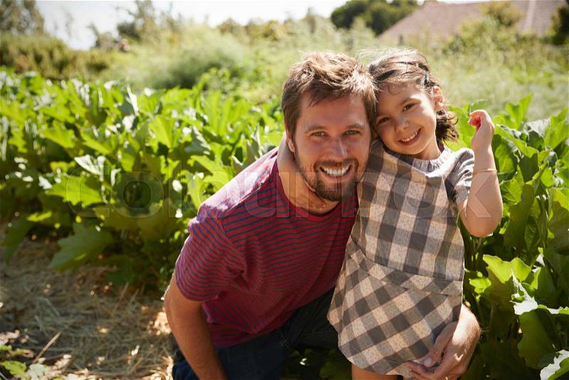 Portrait Of Father And Daughter Standing On Community Allotment, stock photo